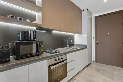 a kitchen with a sink and a microwave at Designer Studio w Burj Khalifa view in Peninsula in Dubai
