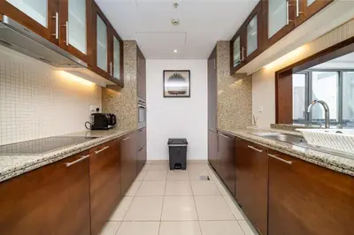 a large kitchen with wooden cabinets and a sink at Downtown Luxury 1 Bed with City Skyline Views in Dubai