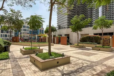a courtyard in a city with trees and buildings at Downtown Luxury 1 Bed with City Skyline Views in Dubai