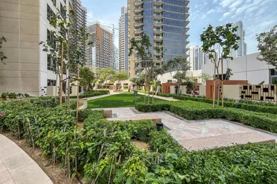 a garden in the middle of a city with tall buildings at Downtown Luxury 1 Bed with City Skyline Views in Dubai