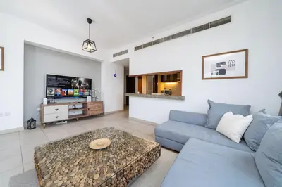 a living room with a blue couch and a table at Downtown Luxury 1 Bed with City Skyline Views in Dubai