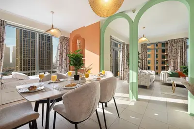 a dining room with a table and chairs and a couch at Serene Cozy 2BR Near Burj Khalifa in Dubai