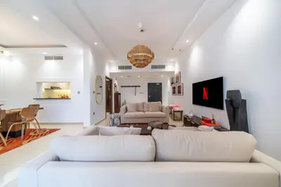 a living room with a white couch and a table at Cityscape & Coastal Charm Elegant 2BR Seaside in Dubai Marina
