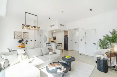 a white living room with a white couch and tables at High-Floor 1BR New Design Steps to JBR Beach in Dubai