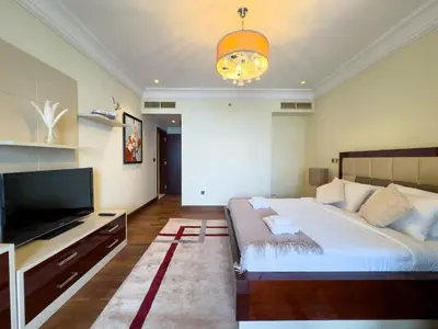 a bedroom with a large bed and a flat screen tv at Luxury 2BR plus Maidrm at Grandeur Res Palm Jumeir in Dubai