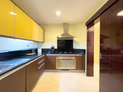 a kitchen with wooden cabinets and a stove top oven at Luxury 2BR plus Maidrm at Grandeur Res Palm Jumeir in Dubai