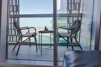 two chairs and a table on a balcony at 65th Floor Penthouse Dubai Marina in Dubai