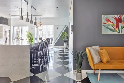 a living room with a yellow couch and a kitchen at 65th Floor Penthouse Dubai Marina in Dubai