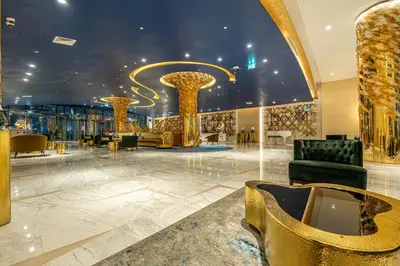 a lobby with gold columns and furniture in a building at Venetian - Luxe Living 1 BR with Stunning Sky Line Views in Dubai