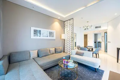 a living room with a couch and a table at Venetian - Luxe Living 1 BR with Stunning Sky Line Views in Dubai