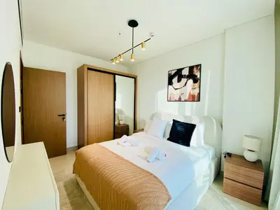 a bedroom with a large bed with two towels on it at Modern & Cozy 1 Bedroom Apartment in JVC 215-GLX-1 in Dubai
