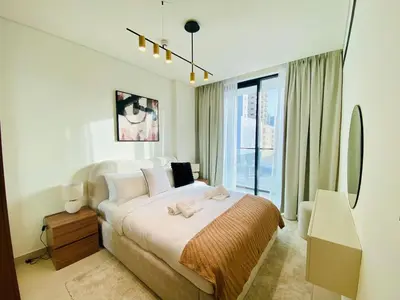 a bedroom with a bed and a large window at Modern & Cozy 1 Bedroom Apartment in JVC 215-GLX-1 in Dubai