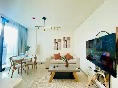a living room with a couch and a tv and a table at Modern & Cozy 1 Bedroom Apartment in JVC 215-GLX-1 in Dubai