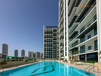 a large swimming pool in front of a building at Bnbeyond's Chic Urban Retreat with Upscale 1BR in Dubai