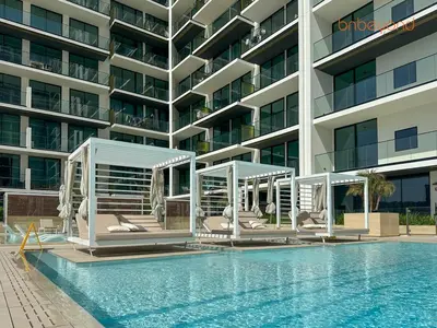 a hotel with a swimming pool next to a building at Bnbeyond's Chic Urban Retreat with Upscale 1BR in Dubai