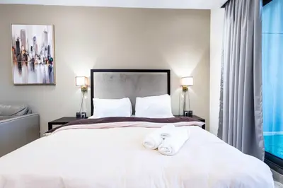 a bedroom with a white bed with towels on it at Burj View Elite Studio Apartment in Dubai