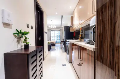 a kitchen with white floors and a black counter top at Burj View Elite Studio Apartment in Dubai