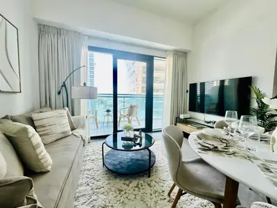 a living room with a couch and a table at Stylish 1br Merano Tower Pool Parking in Dubai