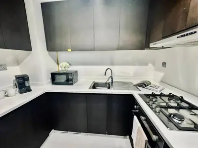 a small kitchen with a sink and a stove at Stylish 1br Merano Tower Pool Parking in Dubai
