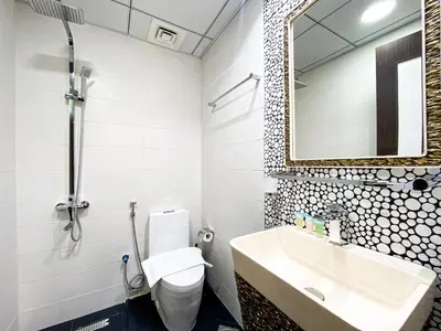 a bathroom with a sink and a toilet and a mirror at Stylish 1-Bedroom-Sleeps 4- Apartment -Bayz by Danube, Business Bay-29 in Dubai