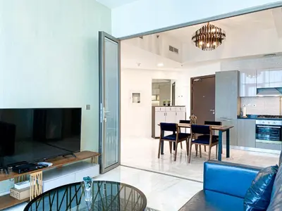 a living room with a blue couch and a dining room at Stylish 1-Bedroom-Sleeps 4- Apartment -Bayz by Danube, Business Bay-29 in Dubai