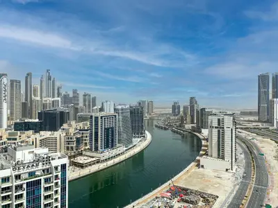 a view of a city with a river and buildings at Stylish 1-Bedroom-Sleeps 4- Apartment -Bayz by Danube, Business Bay-29 in Dubai