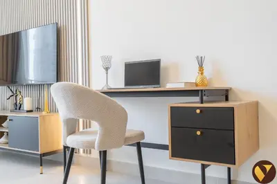 a room with a desk and a chair and a dresser at Vogue Creek Harbour Creek Crescent Waterfront Living Close to Downtown, Burj Khalifa and Dubai Mall, One Bedroom Apartment with Balcony and City View, Access to all Amenities in Dubai