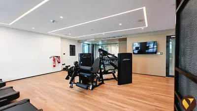 a gym with tread machines and a television in a room at Vogue Creek Harbour Creek Crescent Waterfront Living Close to Downtown, Burj Khalifa and Dubai Mall, One Bedroom Apartment with Balcony and City View, Access to all Amenities in Dubai