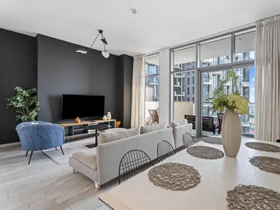 a living room with a couch and a tv at Chic City Escape - 2BR Plus Guest Room at Atria, Business Bay in Dubai
