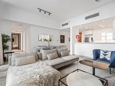 a living room with a couch and a table at Chic City Escape - 2BR Plus Guest Room at Atria, Business Bay in Dubai