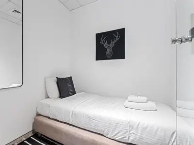 a small bedroom with a bed and a mirror at Chic City Escape - 2BR Plus Guest Room at Atria, Business Bay in Dubai