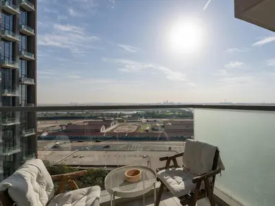 a balcony with two chairs and a table and a view at Chic City Escape - 2BR Plus Guest Room at Atria, Business Bay in Dubai