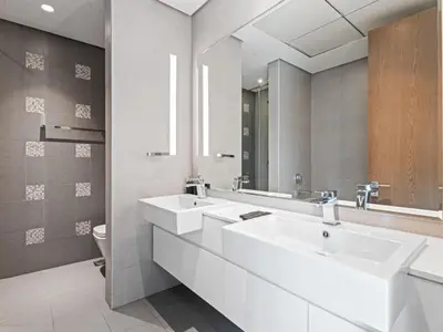 a bathroom with two sinks and a mirror at Chic City Escape - 2BR Plus Guest Room at Atria, Business Bay in Dubai