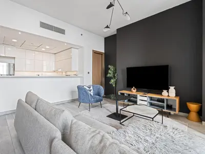 a living room with a couch and a tv at Chic City Escape - 2BR Plus Guest Room at Atria, Business Bay in Dubai