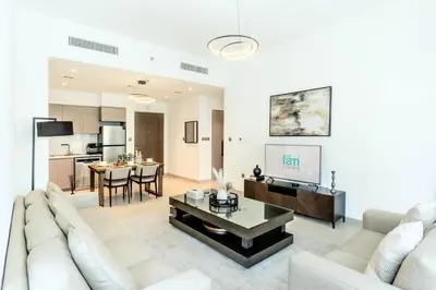 a living room with a white couch and a tv at FAM Living Act Two 1BR Walk to Burj & Dubai Mall in Dubai
