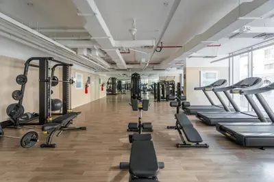 a gym with lots of treadmills and machines at GuestReady - Rooftop Pool l Garden l Nice Balcony in Dubai