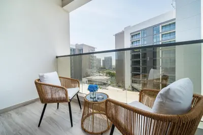 a balcony with chairs and a table and a large window at Luxury unit in the Heart of Dubai Hills in Dubai