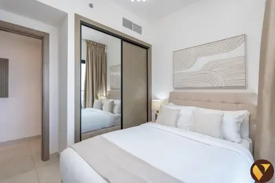a bedroom with a large white bed and a mirror at Vogue Al Jadaf Binghatti Creek near Festival Mall, Three Bedroom Apartment with Balcony and City View, Access to all Amenities in Dubai