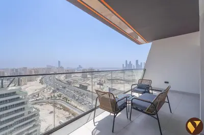 a balcony with two chairs and a view of a city at Vogue Al Jadaf Binghatti Creek near Festival Mall, Three Bedroom Apartment with Balcony and City View, Access to all Amenities in Dubai
