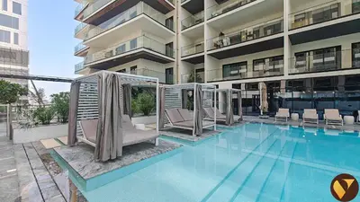 a hotel swimming pool with chairs and a building at Vogue Al Jadaf Binghatti Creek near Festival Mall, Three Bedroom Apartment with Balcony and City View, Access to all Amenities in Dubai