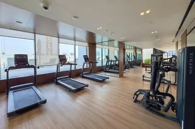 a gym with treadmills and ellipticals in a building at Vogue Al Jadaf Binghatti Creek near Festival Mall, Three Bedroom Apartment with Balcony and City View, Access to all Amenities in Dubai