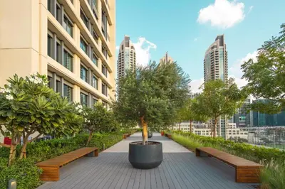 a walkway with benches and trees in a city at Dreamy Apartment,Pool with Burj khalifa View ,5Min Walk to Dubai Mall in Dubai