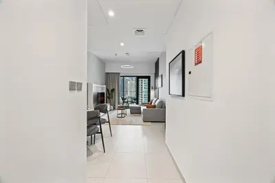 a hallway with white walls and a living room at Dreamy Apartment,Pool with Burj khalifa View ,5Min Walk to Dubai Mall in Dubai