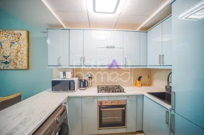 a kitchen with blue cabinets and a stove top oven at Stylish 2BR in Continental Tower Dubai Marina in Dubai