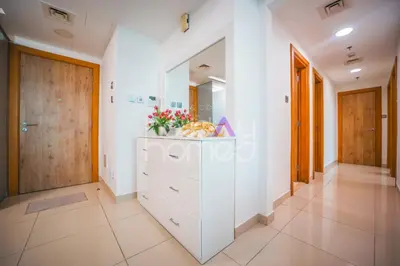 a hallway with a dresser with flowers on it at Stylish 2BR in Continental Tower Dubai Marina in Dubai