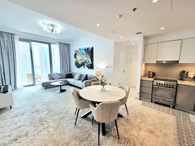 a kitchen and a living room with a table and chairs at SUNRISE HOMES - Stylish 1-BR with Incredible Views - Creekside in Dubai