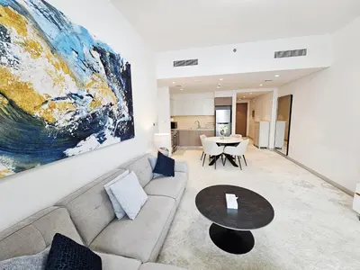 a living room with a couch and a table at SUNRISE HOMES - Stylish 1-BR with Incredible Views - Creekside in Dubai