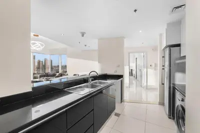 a white kitchen with a sink and a dishwasher at Luxury Apartment 2BR with Sea & Palm View - DAMAC Heights in Dubai