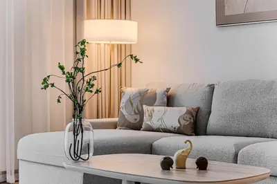 a living room with a couch and a table with a vase at 1BD Apartment at Creek Beach with Lagoon Access in Dubai