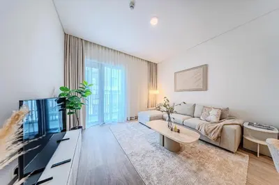 a living room with a couch and a tv at 1BD Apartment at Creek Beach with Lagoon Access in Dubai